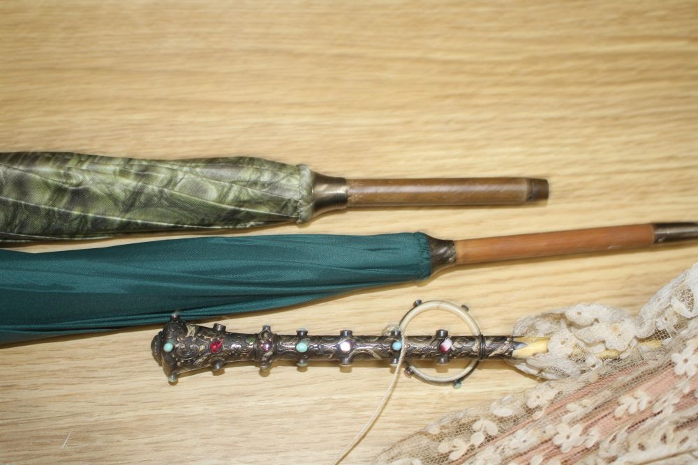 A group of assorted Victorian and later parasols including one with jewelled silver and ivory folding handle